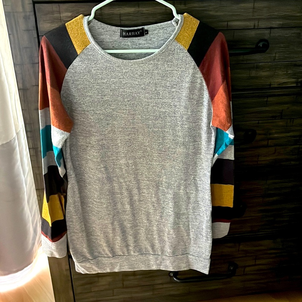Grey sweater with multi colored sleeves. Soft and comfy. Size small.